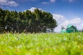 Camp and tent on green grass field under clear sky Royalty Free Stock Photo