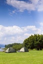 Camp and tent on green grass field under clear sky Royalty Free Stock Photo