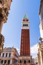 The Campanile between the Doge`s Palace and the Basilica with tourists, Piazza San Marco in Venice in Veneto, Ita