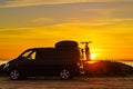 Camper with bicycles on rack camping on beach at sunrise