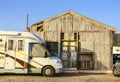 Camper parked in front of a wooden cabin