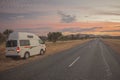 A camper van at the desert road of Namatjira Drive in the Red Centre region of Northern Territory, Australia during sunset.