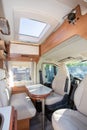 Camper van modern white table and seat interior in luxury motorhome on rv vanlife concept Royalty Free Stock Photo