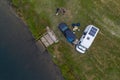 Camper van motorhome with solar panels drone aerial view of two couples living van life near a river and grass in Portugal at