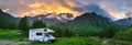 Camper van in the mountains, the Alps, Piedmont, Italy. Sunset dramatic sky and clouds, unique highlands and rocky mountains