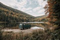 A camper van on the shore of a mountain lake in autumn Royalty Free Stock Photo