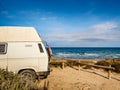 Camper van with surf board on beach Royalty Free Stock Photo