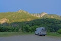 Camper van with bikes in the back in the Romanian mountains in early morning sunlight