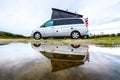 Campervan or motorhome camping on rainy day with rain puddles