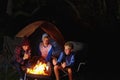 Campfire camaraderie. three young boys sitting by the campfire. Royalty Free Stock Photo