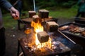 campfire chef cooking juicy, plump s'mores on the stick over the fire