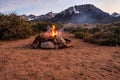 Campfire flames in rock fire pit in desert at base of mountains Royalty Free Stock Photo