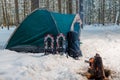 A campfire near a tent in a winter camping