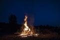 Campfire at night, with its soothing flickering flames and red and orange glow of the burning logs at dark night Royalty Free Stock Photo