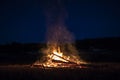 Campfire at night, with its soothing flickering flames and red and orange glow of the burning logs at dark night Royalty Free Stock Photo