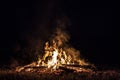 Campfire at night, with its soothing flickering flames and red and orange glow of the burning logs at dark night Royalty Free Stock Photo