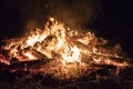 Campfire at night, with its soothing flickering flames and red and orange glow of the burning logs at dark night Royalty Free Stock Photo