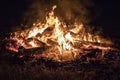 Campfire at night, with its soothing flickering flames and red and orange glow of the burning logs at dark night Royalty Free Stock Photo