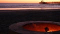 Campfire pit in California USA. Camp fire on twilight ocean beach, bonfire flame by sea water waves. Royalty Free Stock Photo