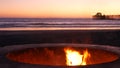 Campfire pit in California USA. Camp fire on twilight ocean beach, bonfire flame by sea water waves. Royalty Free Stock Photo