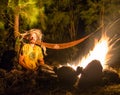 Campfire on a rocky beach with couple sitting Royalty Free Stock Photo