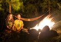 Campfire on a rocky beach with couple sitting Royalty Free Stock Photo