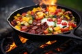 campfire skillet filled with breakfast foods on hot coals Royalty Free Stock Photo