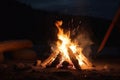 Campfire at touristic camp in the night. Flame and fire sparks on dark background. Generative AI Royalty Free Stock Photo