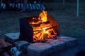 Campfire in a wood-fired barbeque fire pit at the campsite