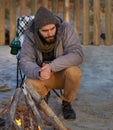 Campfire, wood and man by beach for travel on vacation, adventure or holiday camping. Nature, outdoor and young male