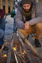 Campfire, wood and men by beach for travel on vacation, adventure or holiday camping. Nature, outdoor and young male