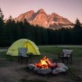 Campground scene at sunset tent, campfire, and serene mountain backdrop