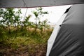 Camping at the beach during rain and bad weather in Sweden with a gray tent and tarp Royalty Free Stock Photo