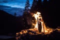 Camping bonfire with yellow and red flames in summer, forest. Copy space