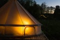 Camping canvas bell tent glows at night