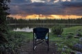 An camping chair overlooking a mountain lake during sunset. Royalty Free Stock Photo