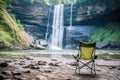 camping chair set up beside gushing waterfall Royalty Free Stock Photo
