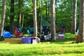 Camping chairs in circle with camp gear under trees