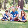 Camping, children and smile in portrait while outside, bonding and happy for outdoor adventure. Kids, face and eating Royalty Free Stock Photo