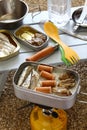 Camping cooking. oiled sardines, sausages and smoked oysters on boiled rice in mess tin.