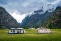 Camping field with camper tents under the rocky mountains of norwegian fjord.