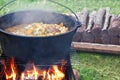 Cooking outdoors in cast iron cauldron Royalty Free Stock Photo