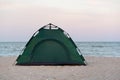 Camping. Green tent by the sea at sunset. Active tourism Royalty Free Stock Photo