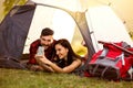 Hipster couple in tent with smart phone