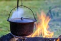 Camping kitchenware - pot on the fire at an outdoor campsite Royalty Free Stock Photo