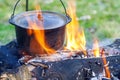 Camping kitchenware - pot on the fire at an outdoor campsite Royalty Free Stock Photo