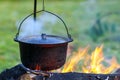 Camping kitchenware - pot on the fire at an outdoor campsite Royalty Free Stock Photo