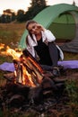 The girl is warming herself by the fire, smiling and looking to the fire Royalty Free Stock Photo