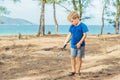 Camping people outdoor lifestyle tourists, summer forest near lazur sea. Blond boy play study survival techniques