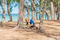 Camping people outdoor lifestyle tourists in summer forest near lazur sea. Blond serious boy in blue t-shirt study